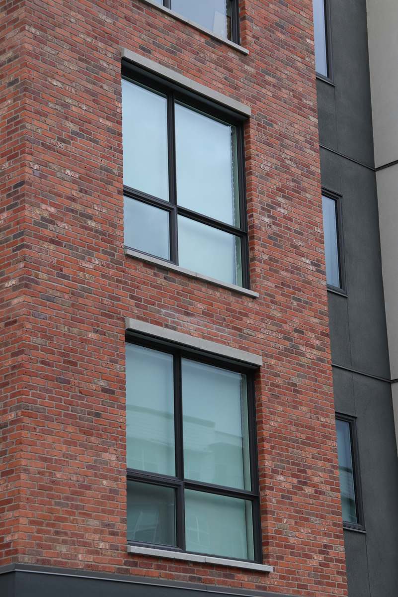 Precast detailing on a red brick building exterior.